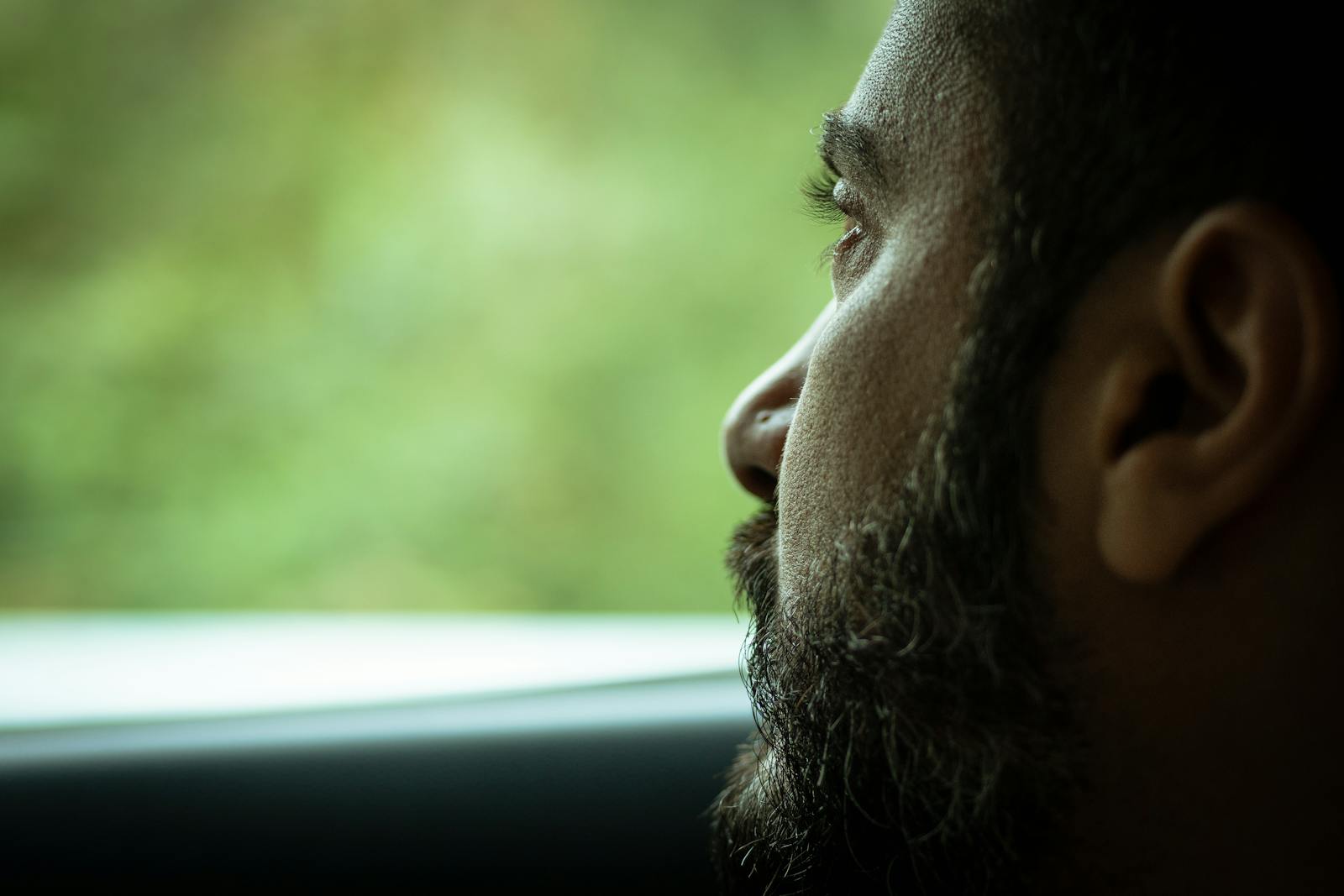 man looking out window