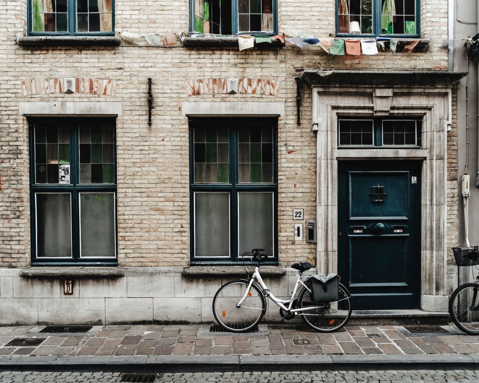 Historic brick facade with a bicycle in Ghent, Belgium, displaying classic European architecture.